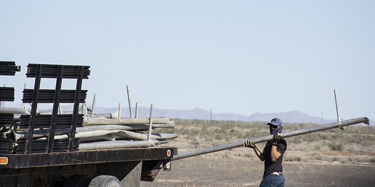 Christian Courtney of Jacobs loads scrap irrigation pipe during the spring cleanup of testing ranges. The pipe was abandoned from a test years before. Photo by Al Vogel, Dugway Public Affairs