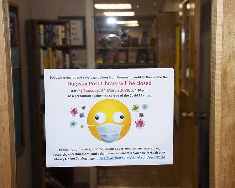 A closed sign is posted on the entry door to the post library