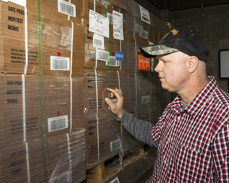 Eric Bruns, Installation Property Book Manager, looks over newly delivered pallets of MRE rations. They will be stored on post for emergencies, to feed military personnel or civilians. Photo by Al Vogel, Dugway Public Affairs.