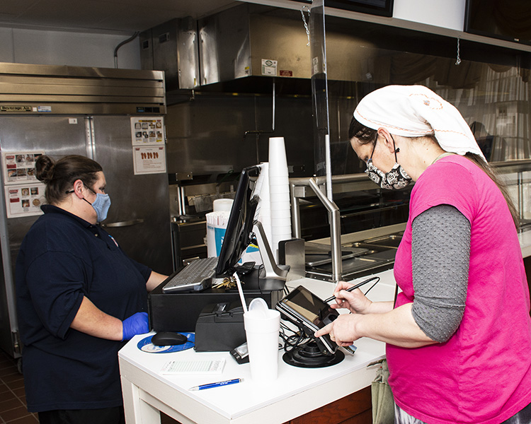 Dawn Lewis works as cashier at the Community Club, ringing up a customer March 8, 2021. Because of pandemic restrictions, there is no indoor seating or home delivery. A grab-and-go lunch is served Monday through Thursday The bar remains closed until pandemic seating restrictions are lifted. Photo by Al Vogel, Dugway Public Affairs