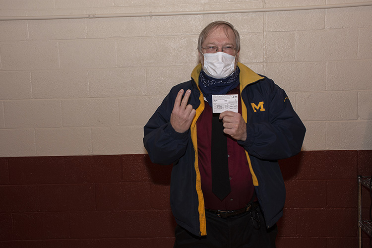 Jack Skeen of the JAG Office holds up two fingers to show hes received his second  and final  inoculation against the COVID-19 coronavirus. Hes also displaying the CDC card he and others with two inoculations receive as proof of their double inoculation.