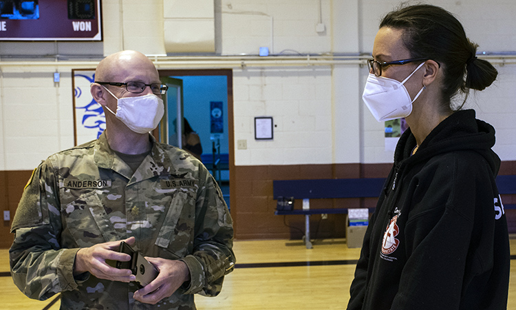Dr. (Maj.) Craig Anderson, Medical Director for the Dugway Health Clinic, speaks with Dr. Susanne Thobe Jan. 14, 2021 in the School Age Services gym during setup at the vaccination site. The clinic first received 110 doses of the Moderna COVID-19 vaccine, given to emergency response personnel Jan. 19-28, 2021.