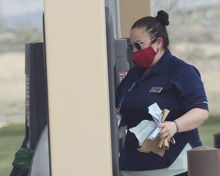 Mercedydece Quinney wears a mask while she loads the paper towel dispenser on the fuel island at Shoppette Express. No more than 10 persons are allowed in the Shoppette at a time, and masks must be worn in the Shoppette and Commissary. Photo by Al Vogel, Dugway Public Affairs.