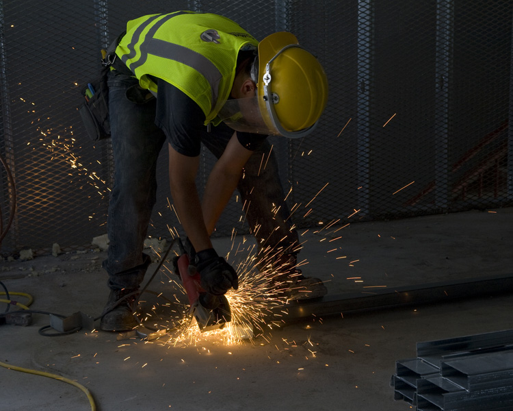 Big D Construction of Salt Lake City is prime contractor to construct the Life Sciences Test Facility. A worker stands amid a burst of sparks as he cuts steel wall posts. Construction began August 2013. Hats off to these workers, who drive a long commute and work all day in searing heat or bitter cold.