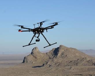 A small unmanned aircraft system (sUAS) is shown in flight at Dugway Proving Ground. The sUAS is one of three platforms utilized during the two-year project to locate golden eagle nests on the installation.