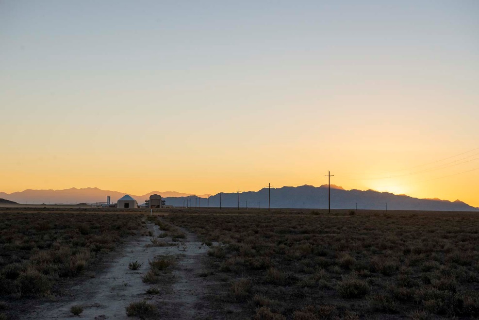 The sun sets on the first Technology Experimentation and Characterization Field Trials (TECFT) held at Dugway Proving Ground. The Active Standoff Chamber (left) and the Joint Ambient Breeze Tunnel (right) can be seen in the distance. Both are unique to the West Desert Test Center and were utilized during the first week of the TECFT event to test new detection technologies.