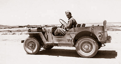 Historical image of a soldier in an Army jeep.