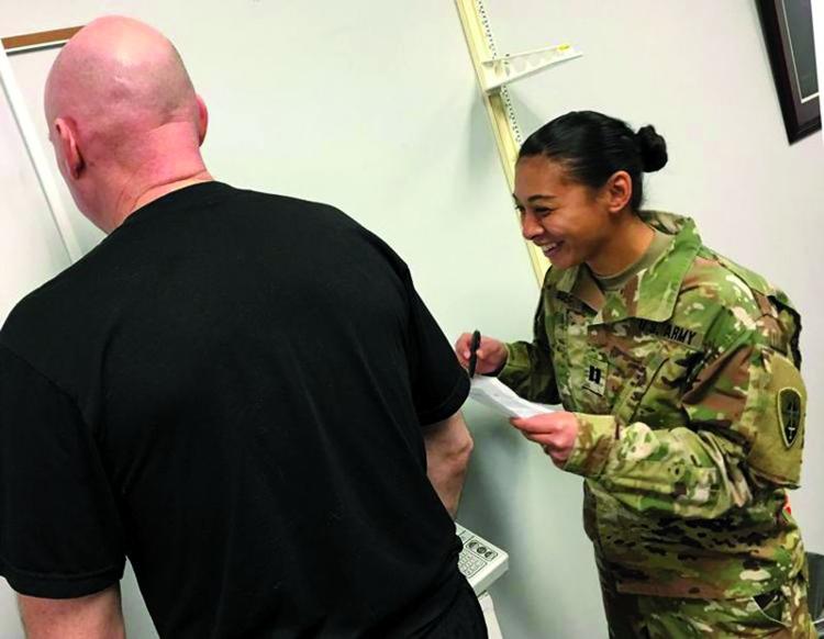 Capt. Rachel Boehme, Headquarters and Headquarters Company commander at USAOTC, weighs a soldier at the start of an eight-week "Shredder" Weight Loss Challenge Jan. 31 as USAOTC kicks off celebrating "50 Years of Operational Testing." (Photo credit:  Michael M. Novogradac/USAOTC Public Affairs Officer)