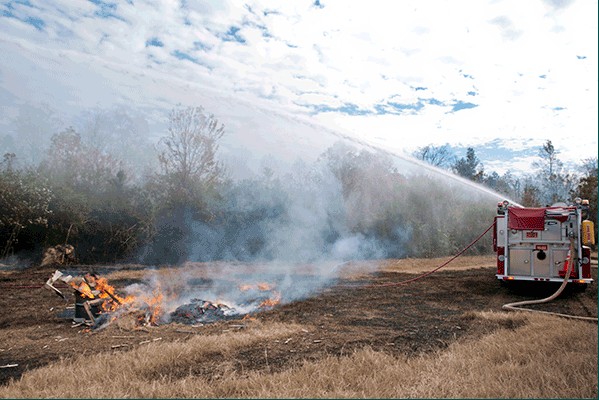 Fort Bragg and Sampson County fire and emergency workers use a water cannon to put out the fire following a simulated plane crash