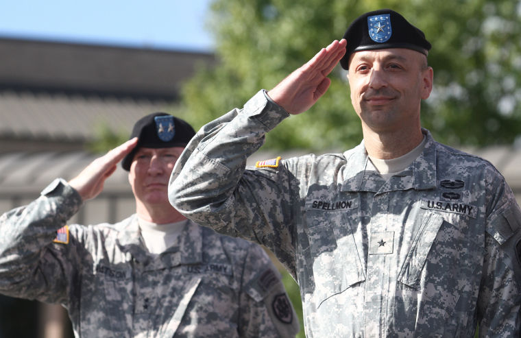 Newly promoted Brig. Gen. Scott A. Spellmon, and Maj. Gen. Bryan G. Watson, left, salute during his promotion ceremony