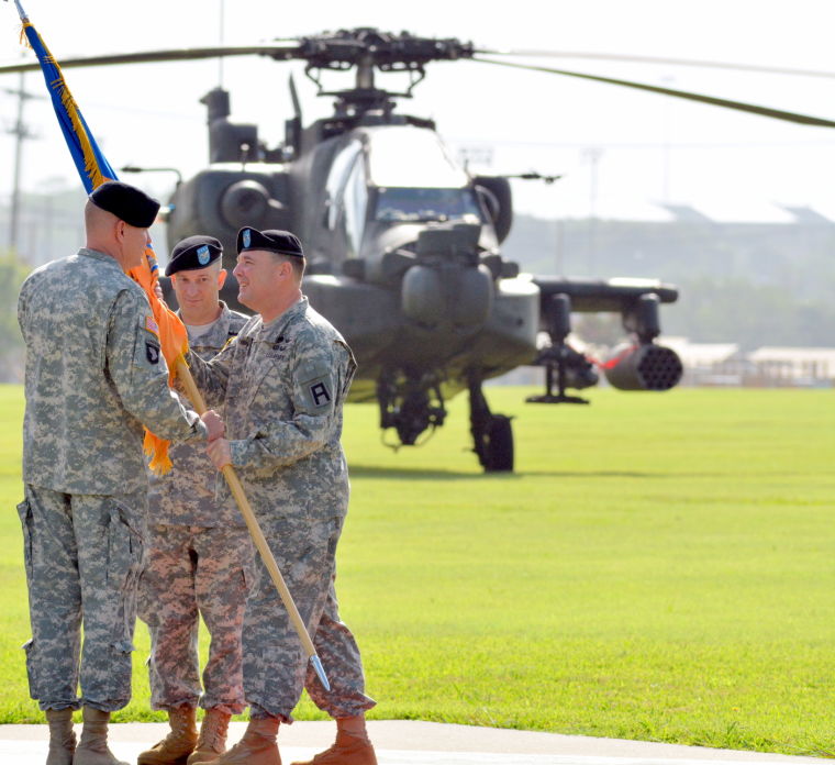 Incoming commander Col. Christopher Albus, right, accepts the brigade colors