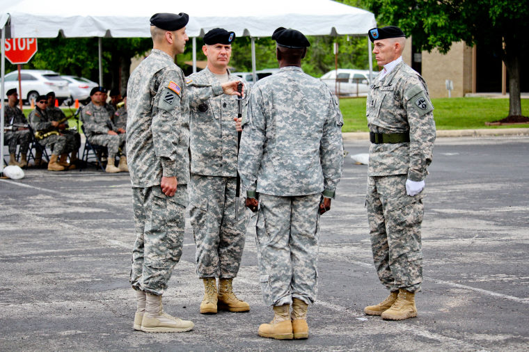 Incoming Command Sgt. Maj. Kenneth Graham takes the saber from outgoing Command Sgt. Maj. Antoine Overstreet