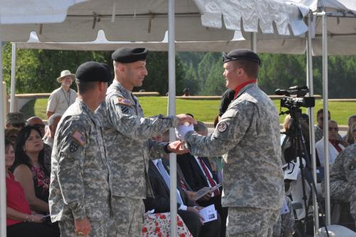 Brig. Gen. Scott Spellmon receives spent shell casing from ordnance fired during ceremony.
