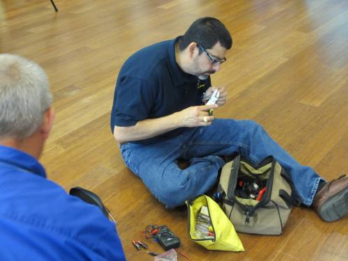 Vicente Gonzales, electronics engineer with OTCs Test Technology Directorate, replaces batteries in remotes at the recent Junior Solar Spring competition in Waco.
