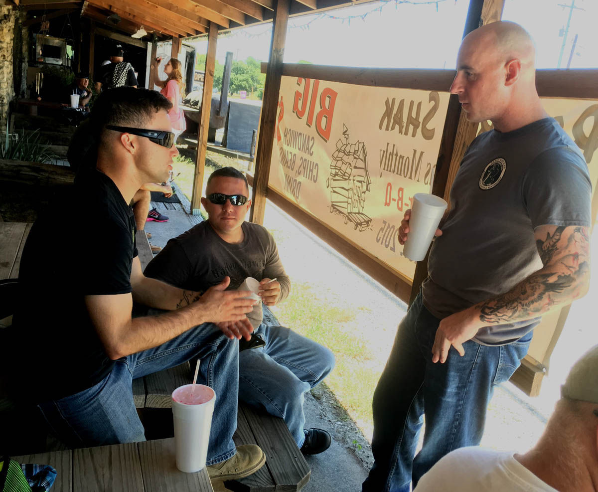 Spc. Patrick Lewis (left) discusses riding tips with Sgt. 1st Class Woody Woodward (seated) and Staff Sgt. John Dennison