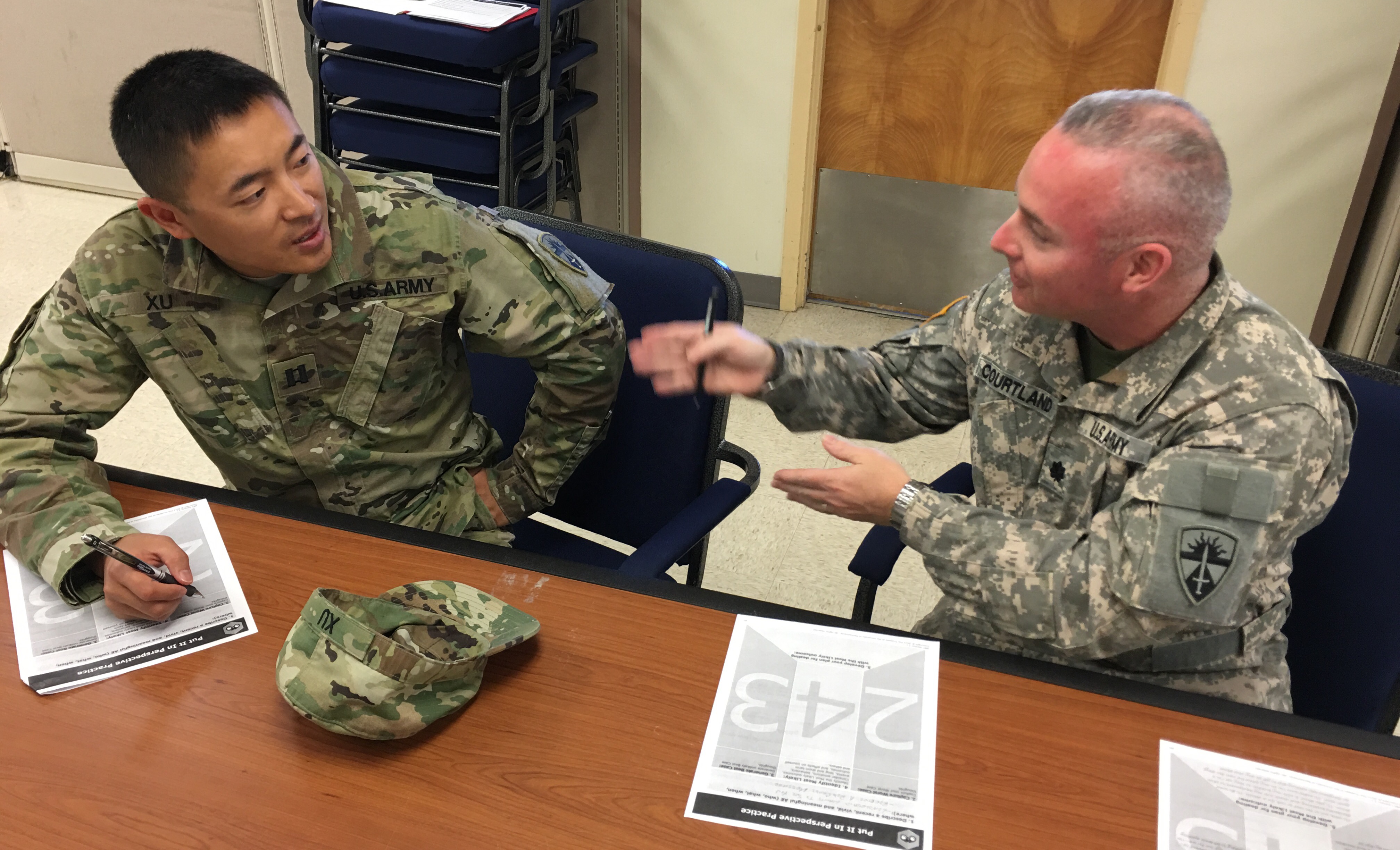 Capt. Li Xu (left) discusses shared everyday experience with Lt. Col. Christopher Courtland