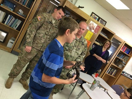 Blayne Smith does show-and-tell of his ball python, Killer, as Sgt. Jacob Wilson (left) and Master Sgt. Earnest Vance listen to presentation (photo by Michael Novogradac, OTC Public Affairs)