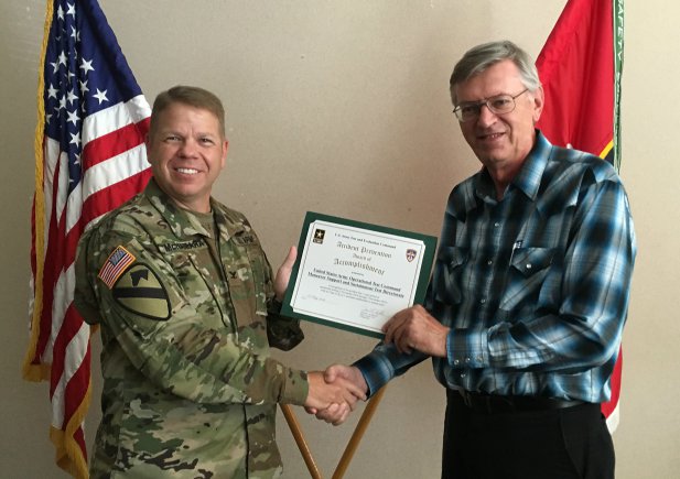 Col. Ronald W. McNamara presents Dennis McCain with award