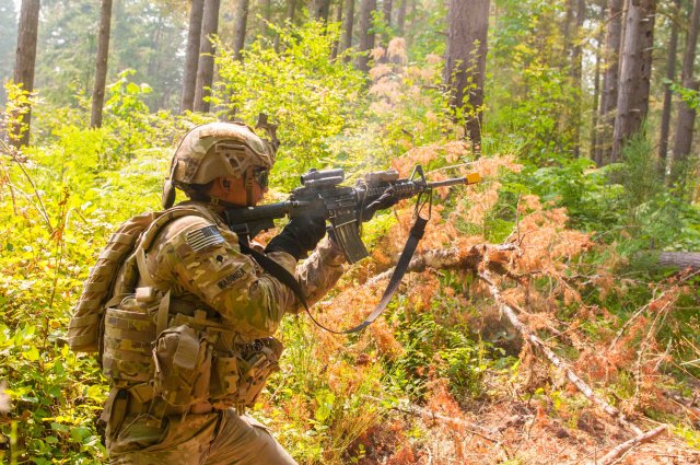 Spc. Paolo Wabinga rushes and fires his weapon