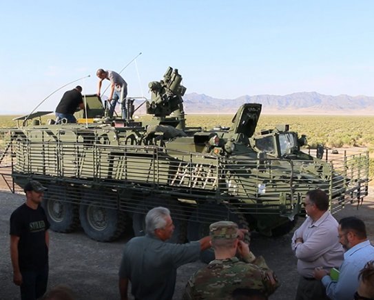 Observers watch as technicians prepare the Army's Stryker Nuclear, Biological, Chemical, Reconnaissance Vehicle for Joint Chemical Agent Detector system Stryker-On-The-Move tests at Target S Grid at Dugway Proving Ground, July 2017. The JCAD will be integrated with the Stryker vehicle as a replacement for the Automatic Chemical Agent Detection Alarm, which will no longer be manufactured for and fielded by the Army. Photo captured from video by Darrell L. Gray, Dugway Proving Ground Public Affairs. (Photo Credit: U.S. Army)