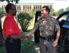 U.S. Army Operational Test Command's Safety Manager Reginald E. Jones, greets Texas State Trooper Sgt. David Roberts (Killeen State Trooper barracks) upon arrival to share information on traffic safety and distracted driving during OTC's command safety stand down Aug. 30.  (Photo Credit: Mr. Michael M Novogradac (Hood))