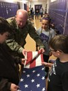 Sgt. 1st Class Ryan Neal, a research development test and evaluation non-commissioned officer in Operational Test Command's Maneuver Test Directorate, shows Florence Elementary School students how to tuck in edges and corners to get the best flag fold during flag etiquette training at Florence Elementary School, Florence Texas, on Jan. 20, 2017. (Photo Credit: Mr. Michael M Novogradac (Hood))